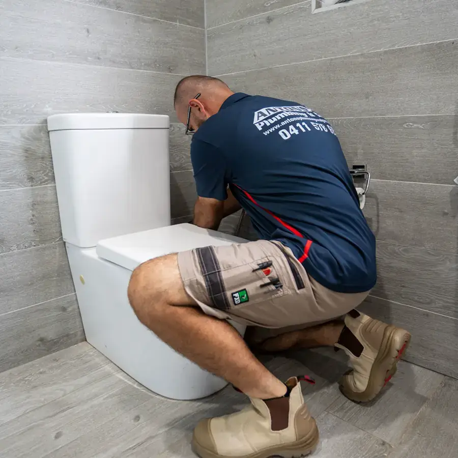 Antons plumber working beside a bathroom fixture