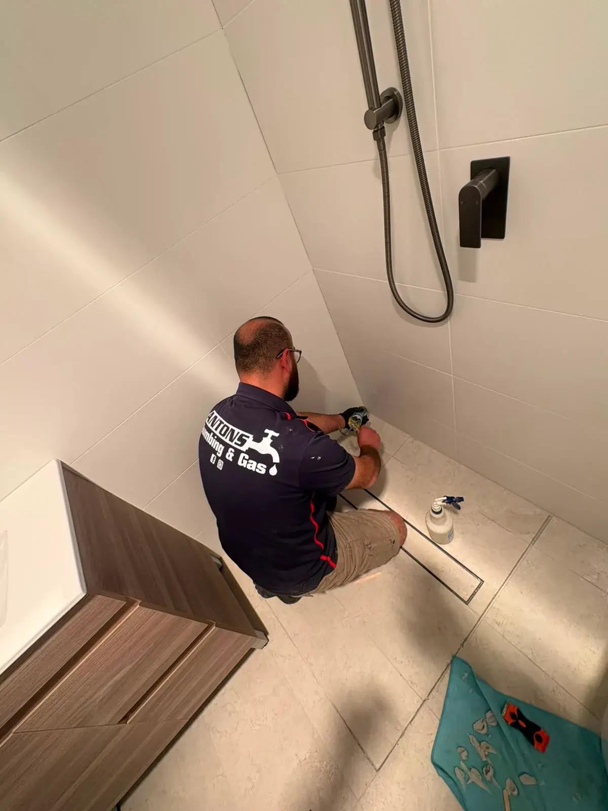 Antons plumber completing a bathroom floor-drain repair